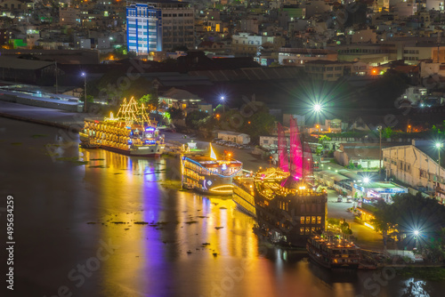 Enjoy the Nha Rong wharf and Bach Dang harbor in Ho Chi Minh City (Saigon). Colorful Saigon river at night.. Travel concept. © CravenA