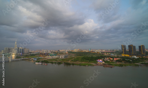 Aerial view of Bitexco Tower, buildings, roads, Thu Thiem 2 bridge and Saigon river in Ho Chi Minh city - Far away is Landmark 81 skyscrapper. This city is a popular tourist destination of Vietnam