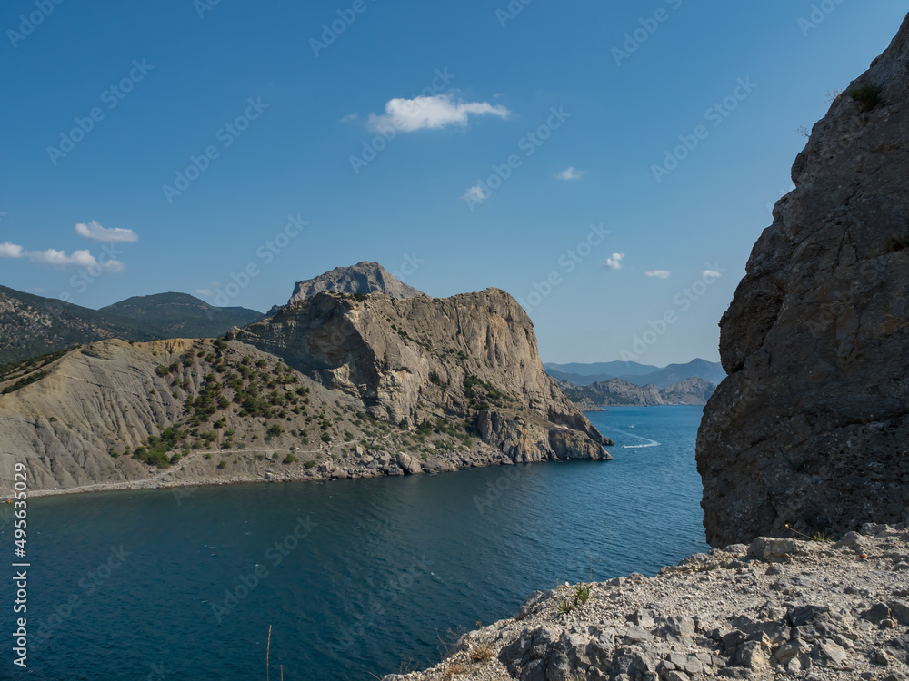 Mountain landscape. View of the sea and rocky mountains. Summer day. The stones form the frame. The concept of travel and vacation in the mountains without people Mountain landscape. View of the sea and rocky mountains. Summer day. The stones form the frame. The concept of travel and vacation in the mountains without people