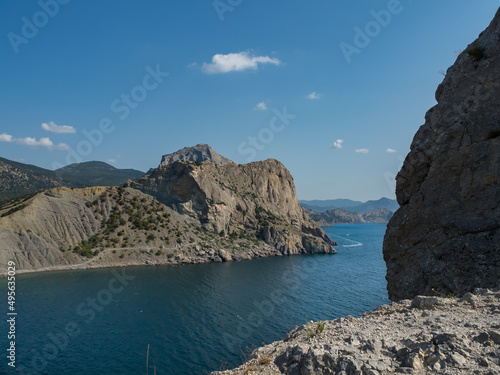 Mountain landscape. View of the sea and rocky mountains. Summer day. The stones form the frame. The concept of travel and vacation in the mountains without people