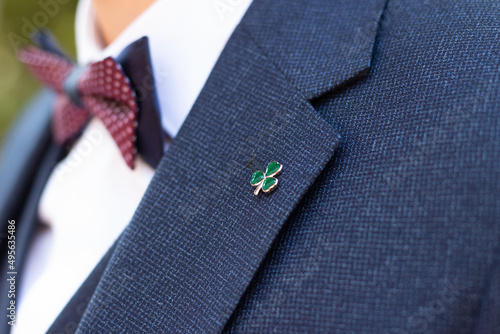 Fotografiet Closeup shot of a small three-leaf clover on the groom's suit