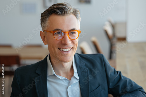 Wallpaper Mural Confident smiling mature businessman wearing stylish eyeglasses sitting in modern office