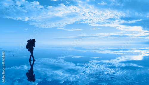 Fototapeta Naklejka Na Ścianę i Meble -  Silhouette of a lonely photographer girl taking a photo of Salt Lake at amazing sunset reflected in water - Salt lake, Ankara