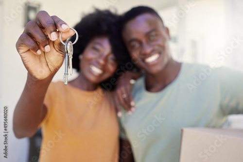 A new chapter starts today. Shot of a young couple holding the keys to their new house.