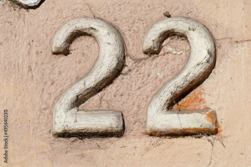Hausnummernschild Nummer Zweiundzwanzig an einer braunen Hauswand, Deutschland photo