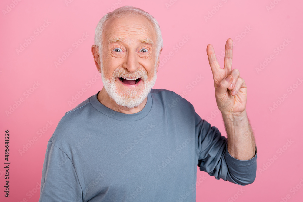 Photo of funny impressed retired man grey sweater showing v-sign isolated pink color background Photo of funny impressed retired man grey sweater showing v-sign isolated pink color background