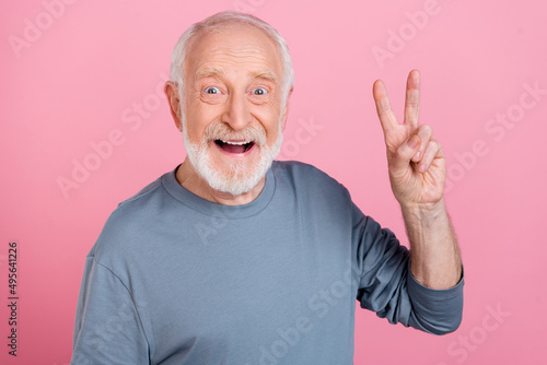 Photo of funny impressed retired man grey sweater showing v-sign isolated pink color background