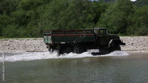 a truck travels across a mountain river