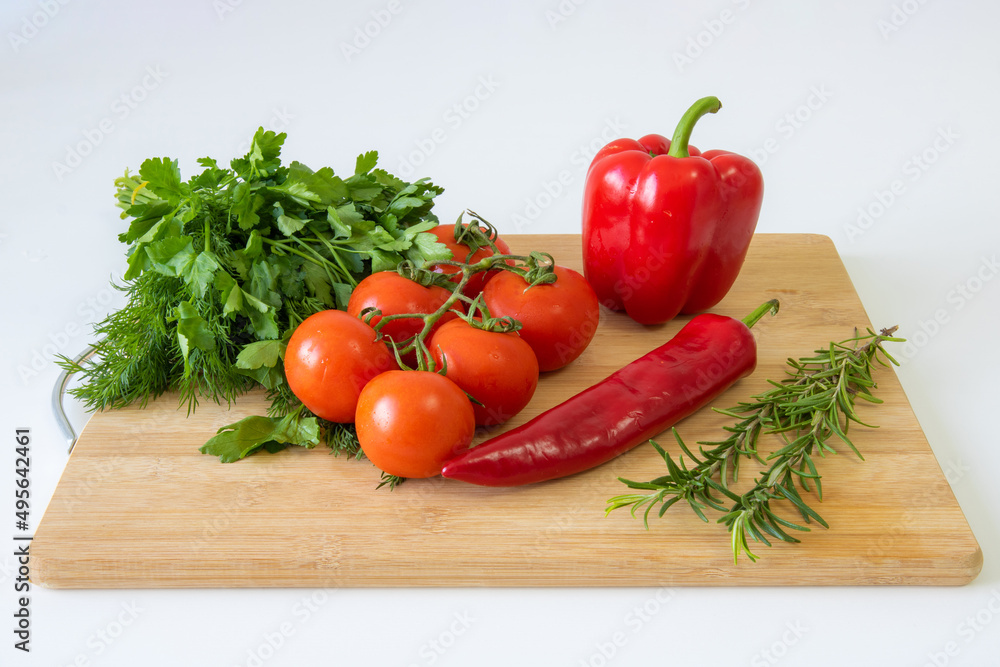 Vegetables on a wooden background, peppers and tomatoes, greens Vegetables on a wooden background, peppers and tomatoes, greens
