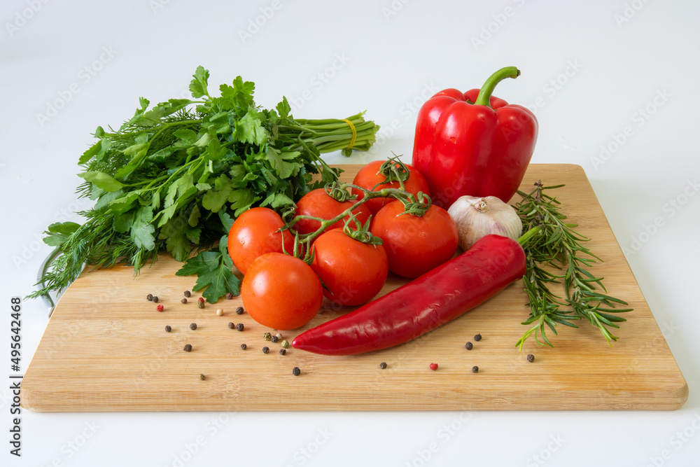 Vegetables on a wooden background, peppers and tomatoes, greens Vegetables on a wooden background, peppers and tomatoes, greens