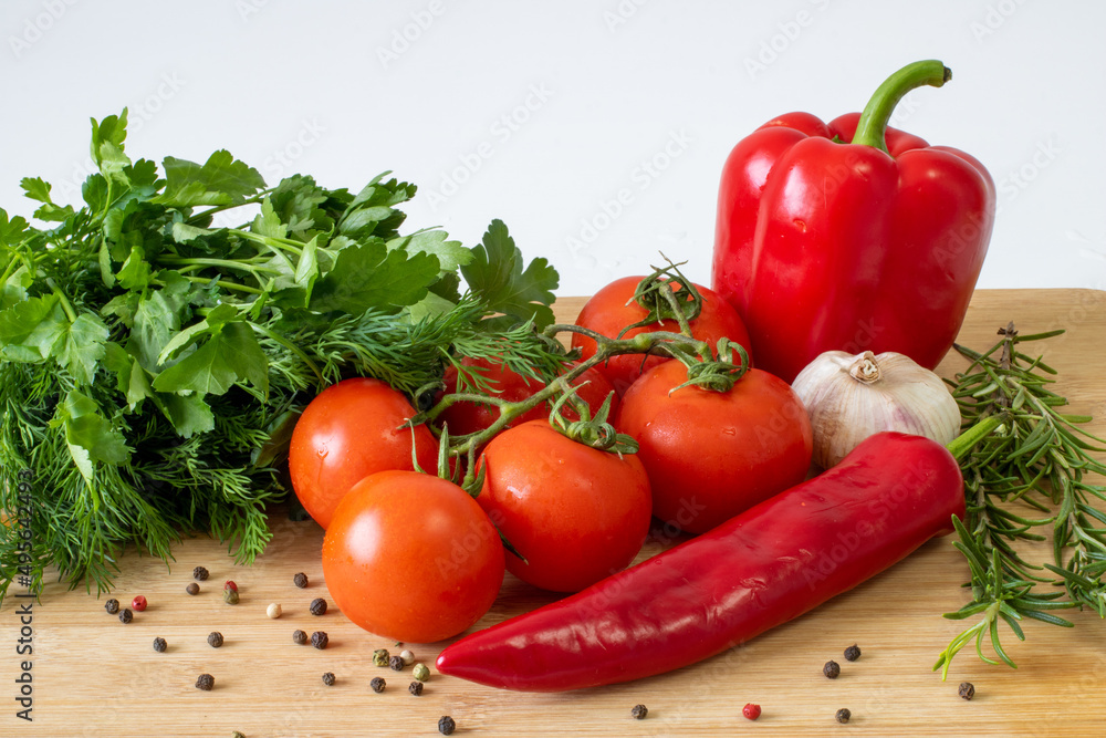 Vegetables on a wooden background, peppers and tomatoes, greens Vegetables on a wooden background, peppers and tomatoes, greens