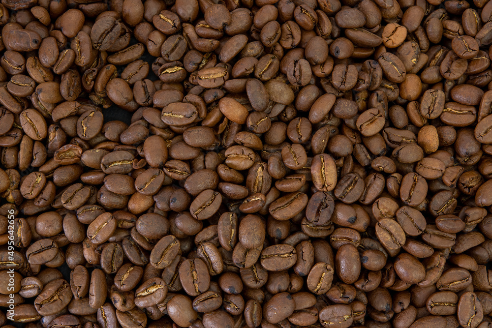 Naklejka premium Macro coffee beans background. Close up photographed coffee beans, coffee beans wallpaper