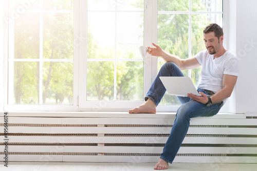 Free Download handsome young man with laptop at home - GFXLoad