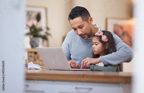 Will you help me with this. Shot of a father helping his daughter with her school work using a laptop.