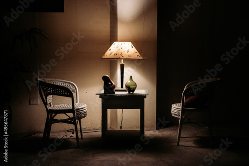 Lamp on a table illuminating the dark room photo