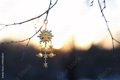 Konstfotografi Solar golden amulet on branch, natural sunny blurred background