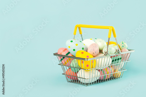 Happy Easter. Colored easter painted eggs in a shopping basket with copy space