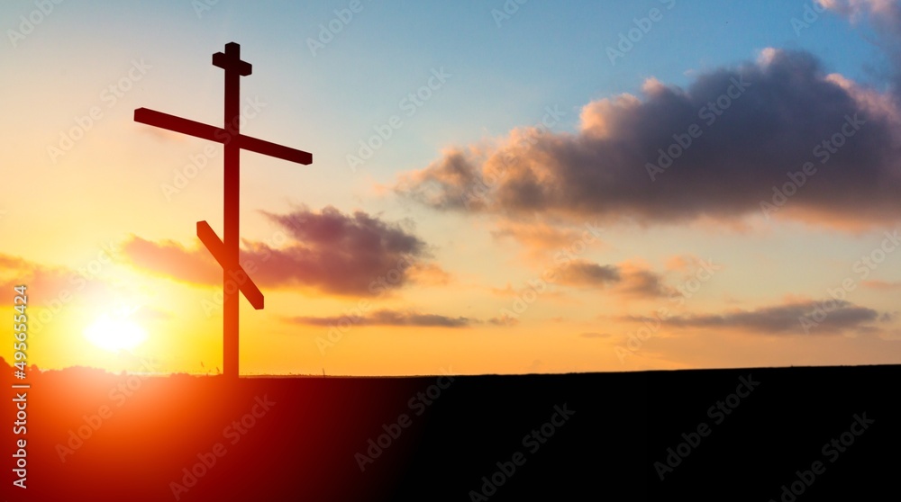 A christian cross at a scenic sunset or sunrise