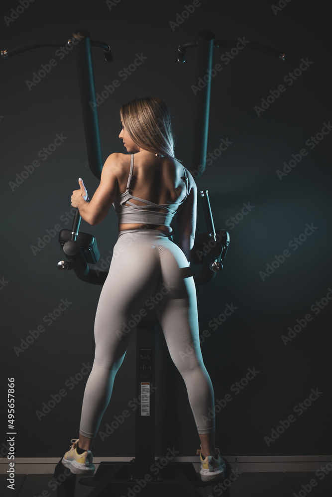 Strong woman posing on a back machine.natural bodybuilding concept