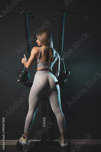 Strong woman posing on a back machine.natural bodybuilding concept