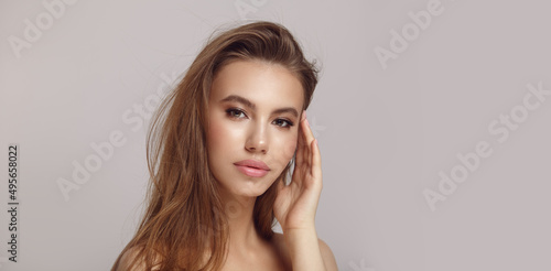 Woman with long loose hair and elegant makeup in studio