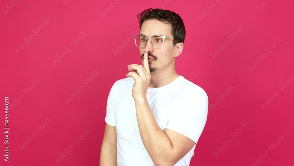 Man with glasses and doing silence gesture Man with glasses and doing silence gesture