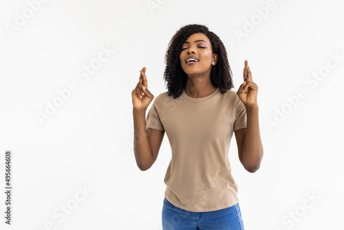 Wallpaper Mural Beautiful young Afro American woman is holding fingers crossed and smiling, isolated on white background Torontodigital.ca