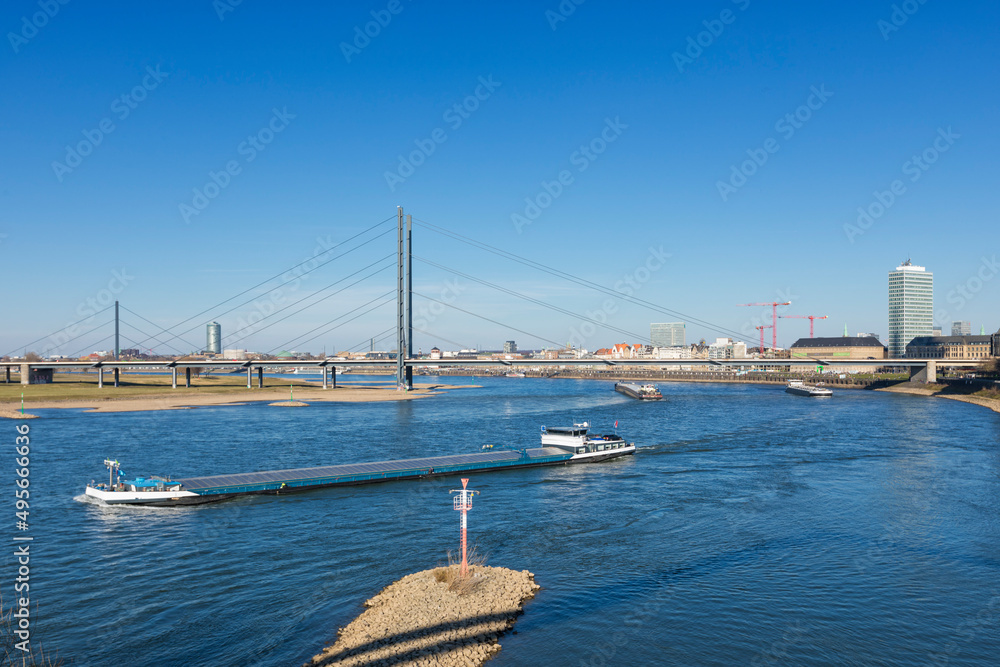 River Rhine with barges passing Rheinkniebrücke bridge at Dusseldorf River Rhine with barges passing Rheinkniebrücke bridge at Dusseldorf