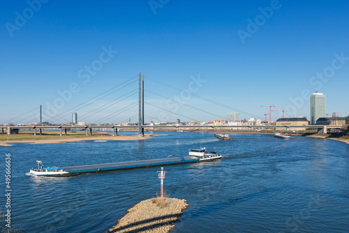 River Rhine with barges passing Rheinkniebr  cke bridge at Dusseldorf