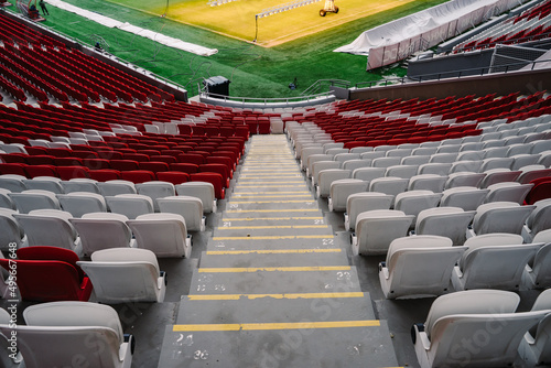 Descending onto the stadium football pitch. Stairs between rows of seats. 