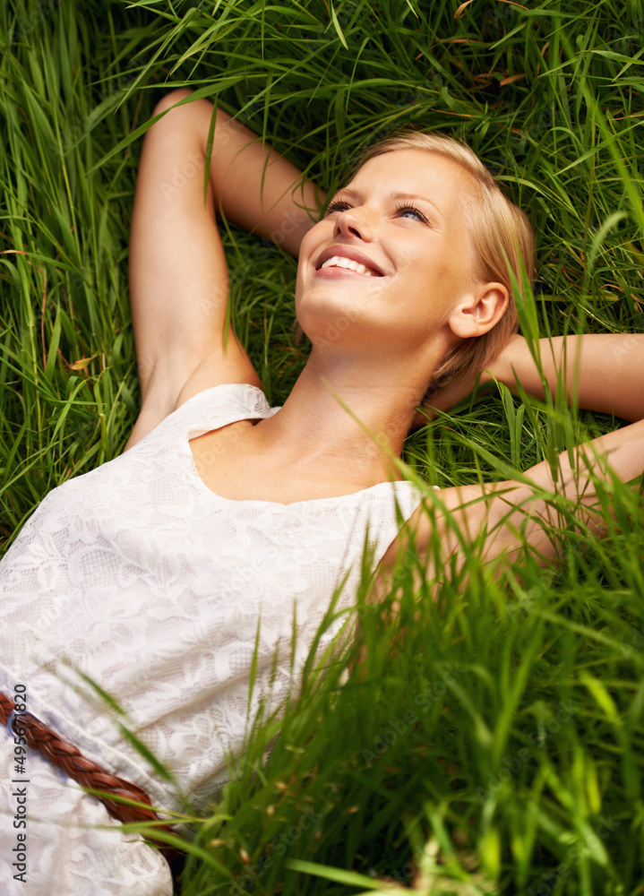 Relaxed in natures calm embrace. An attractive young woman lying in an open green field. Relaxed in natures calm embrace. An attractive young woman lying in an open green field.