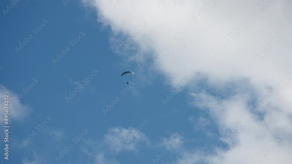 Parachute sky-diver flying high up in the sky on a sunny day. Slow motion. Extreme sports activities concept. Parachute sky-diver flying high up in the sky on a sunny day. Slow motion. Extreme sports activities concept.