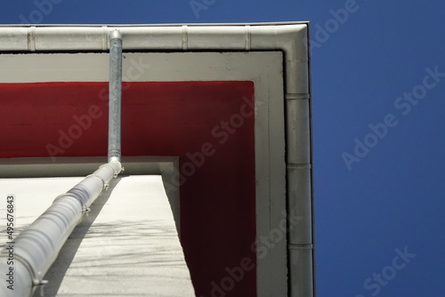 Very steep angle view under red painted gable and rain gutter under blue sky (horizontal), Kaiserslautern, RLP, Germany