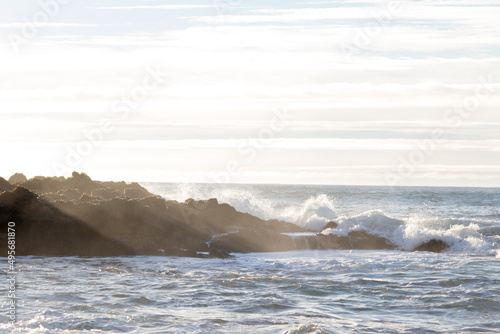 waves hitting rocks on the shore and beach