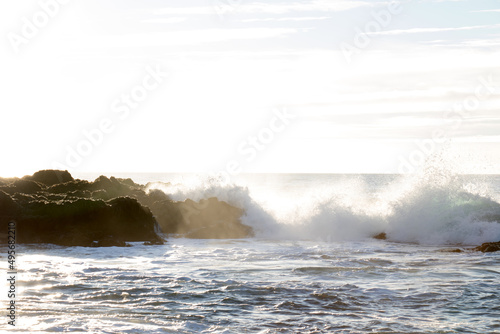 waves hitting rocks on the shore and beach