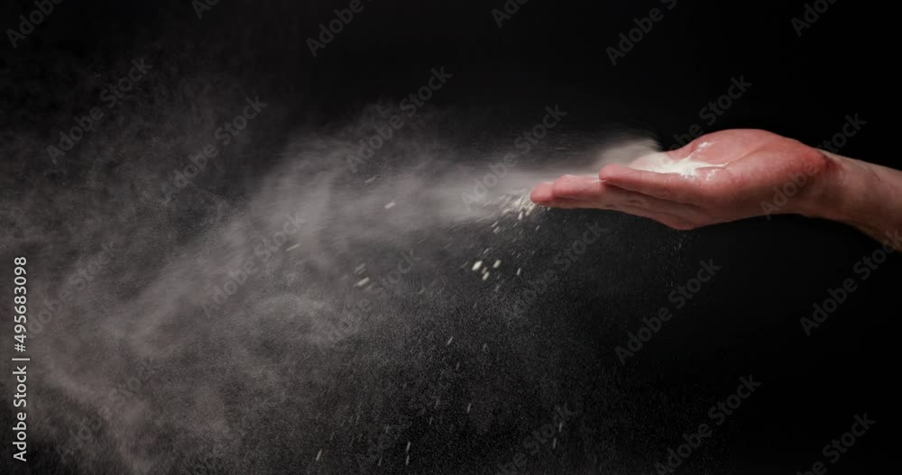 White flour powder flying against dark background