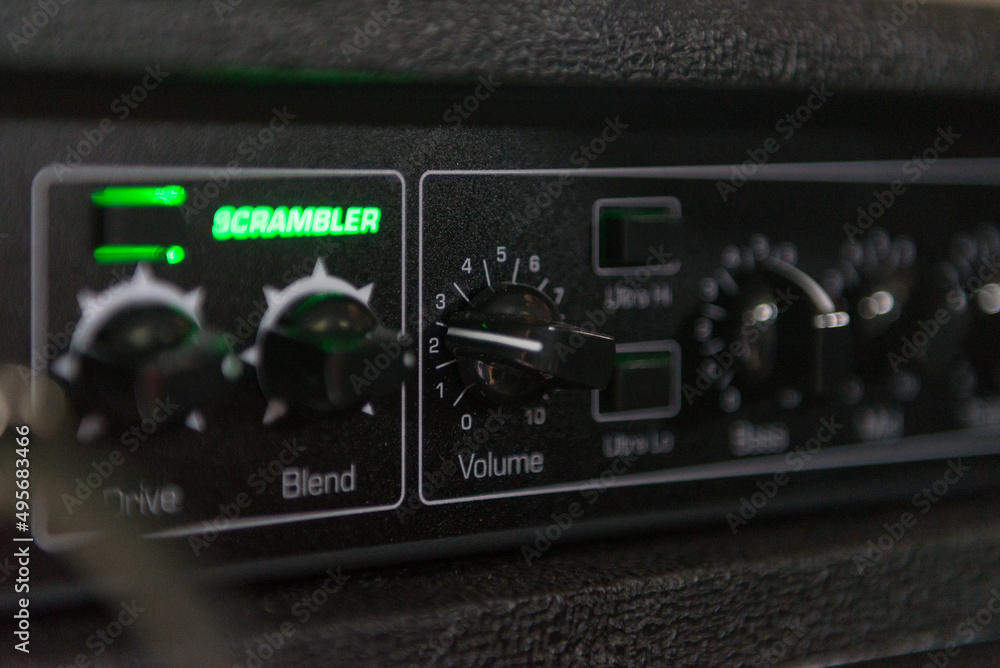 Details of a bass amp with knobs for volume, mix and other buttons to