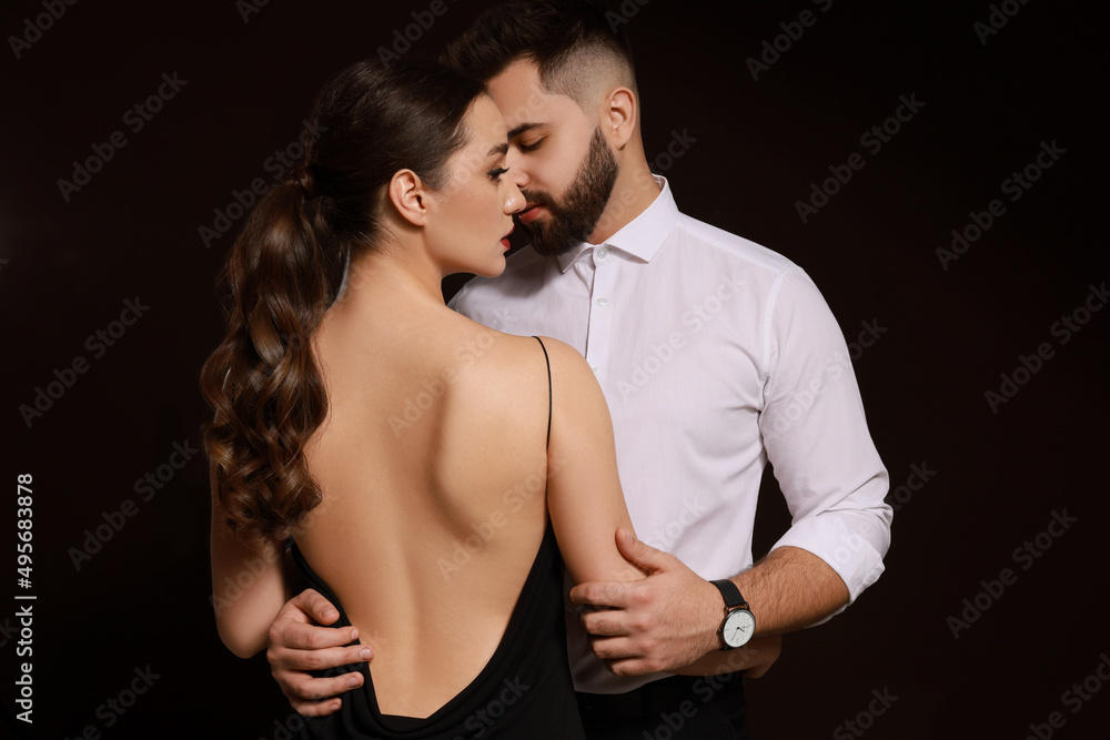 Handsome bearded man with sexy lady on dark background Handsome bearded man with sexy lady on dark background