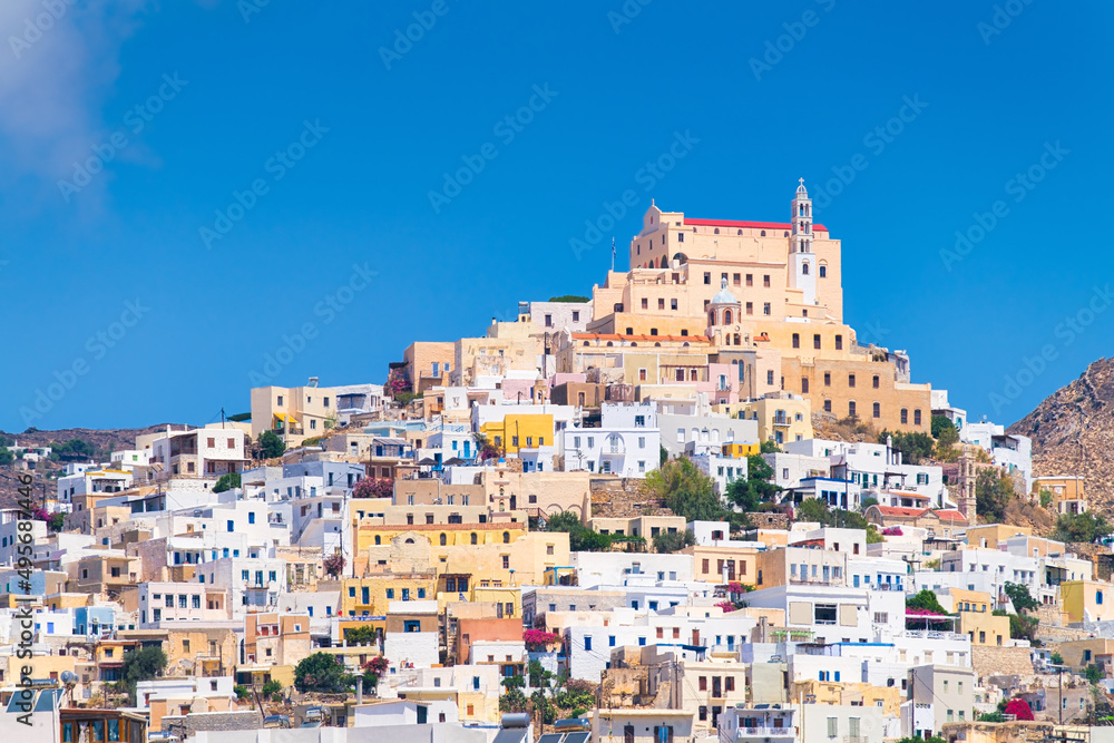 Ermoupolis town, Greece. A town on the side of a mountain. Houses and streets in Greek architecture. Photography for travel and adventure. Cascading arrangement of buildings on the hillside.