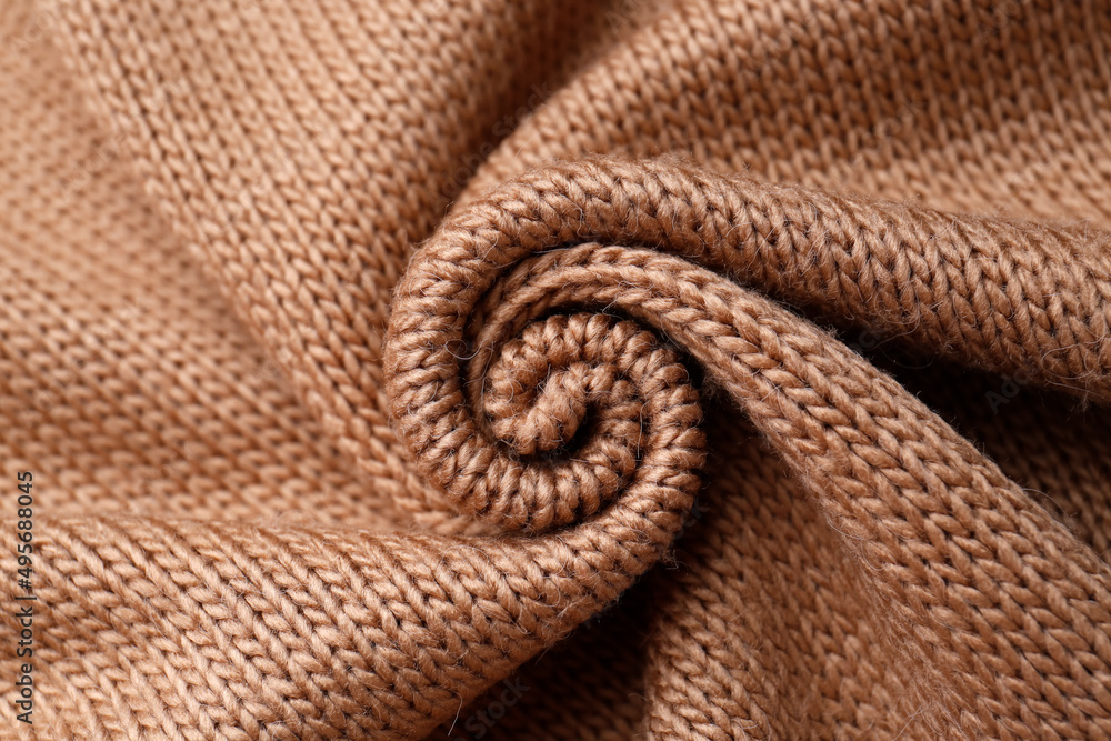 Fototapeta premium Brown knitted fabric as background, top view