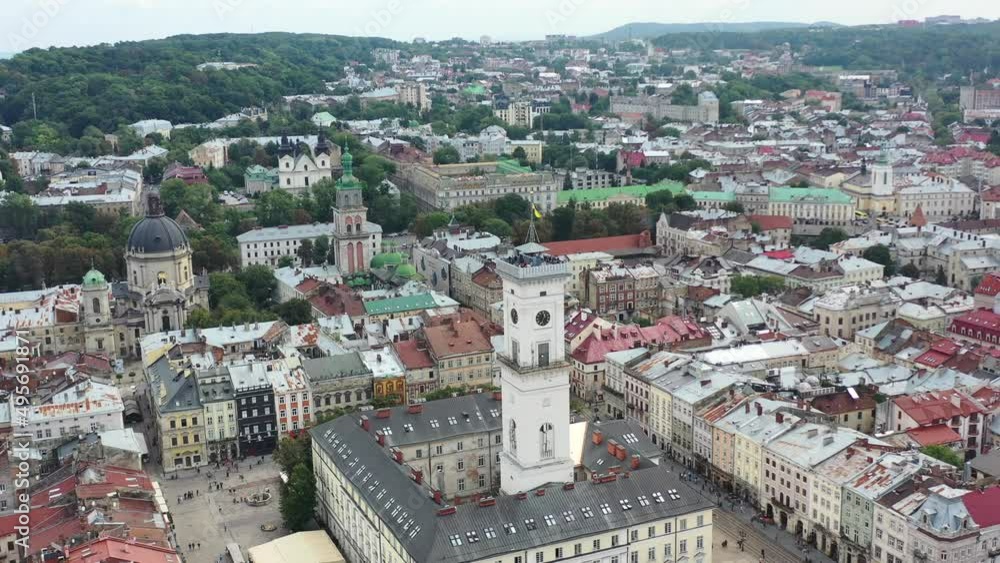 Rynok Square in Lviv Ukraine with the Ukrainian flag flying on top of a tower in city hall surrounded by old European buildings Rynok Square in Lviv Ukraine with the Ukrainian flag flying on top of a tower in city hall surrounded by old European buildings