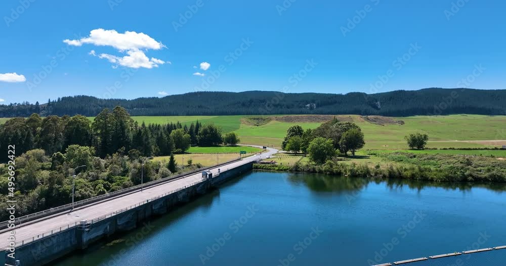 Close up flight across dam lakeside to verdant pasture and forests - NZ Close up flight across dam lakeside to verdant pasture and forests - NZ