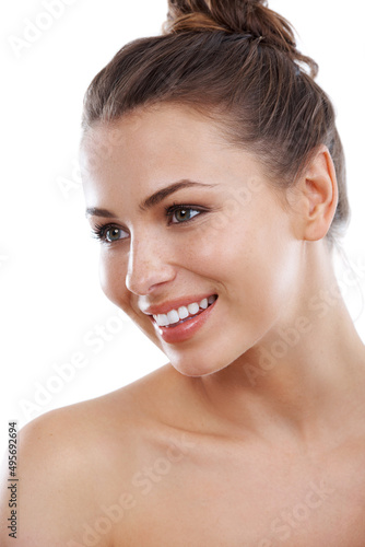 Shes got a brilliant smile. Beautiful young woman with bare shoulders smiling while isolated on a white background.