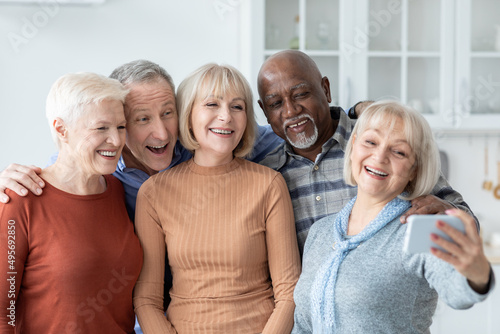 Five cheerful elderly people taking selfie on mobile phone