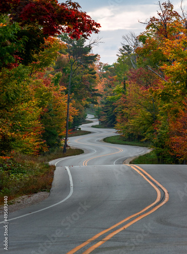 Bumpy curvy road through an autumn forest in Door County, Wisconsin, the USA at sunset or sunrise