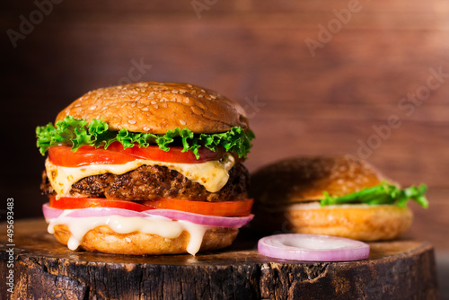 Close-up of delicious homemade burgers on a wooden table on a dark background beef hamburger freshly cooked delicious
