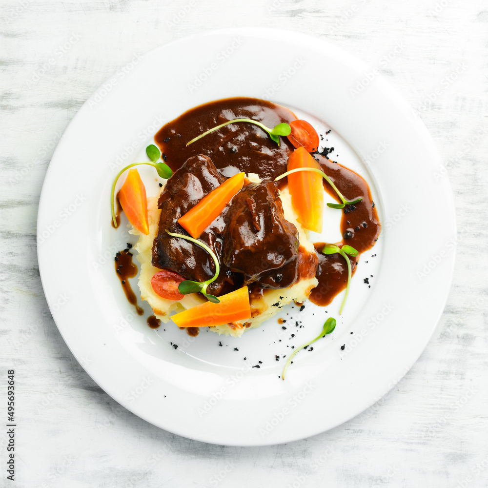 Mashed potatoes with veal sauce and pieces of meat, boiled carrots. Restaurant menu. Top view.