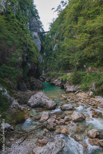 Beautiful scene of water streaming running between Alps Mountains Gorge in Slovenia photo