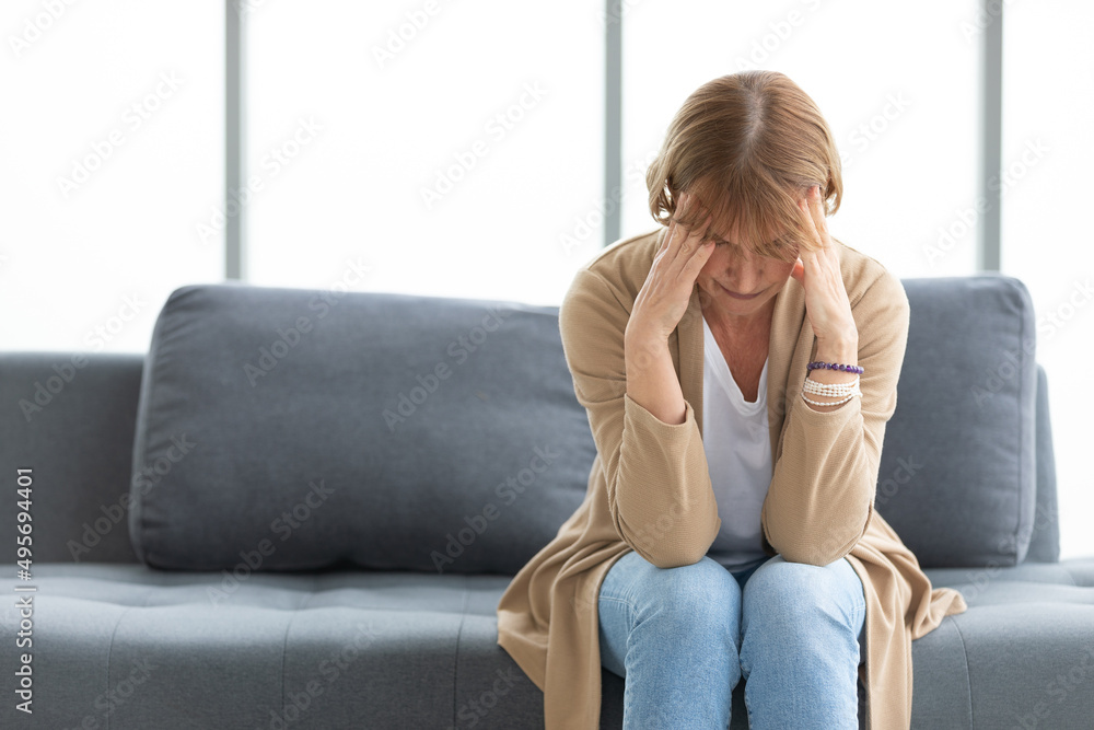 senior woman have a headache on a sofa senior woman have a headache on a sofa