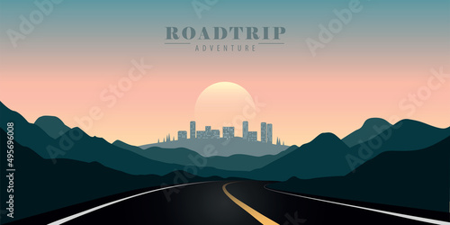 road trip in the mountains towards the city at sunset